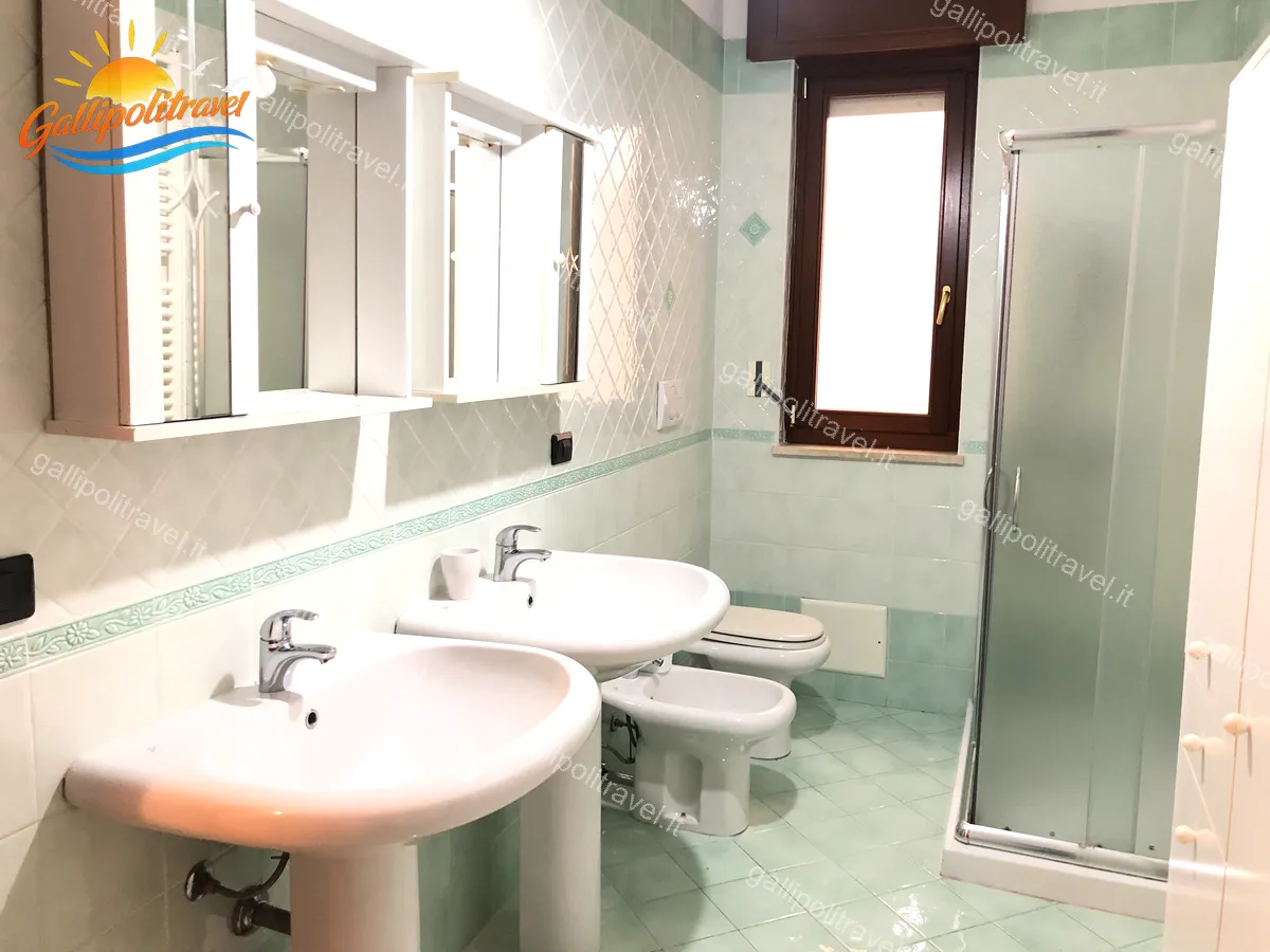 Bagno con piastrelle verde menta e doppio lavabo del Trilocale D1/3 Gallipoli