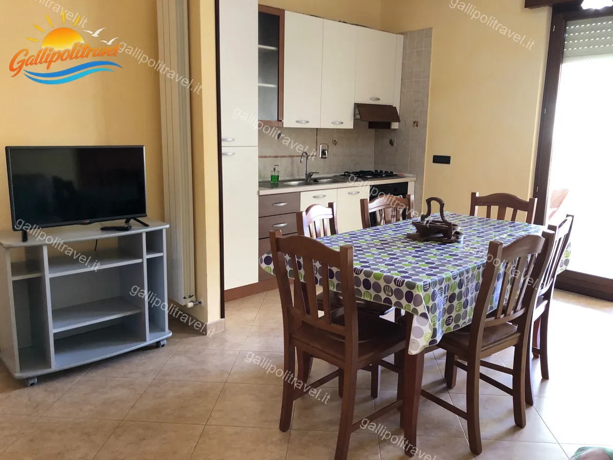 Zona pranzo del Trilocale D1/3 con angolo cottura e porta-finestra luminosa
