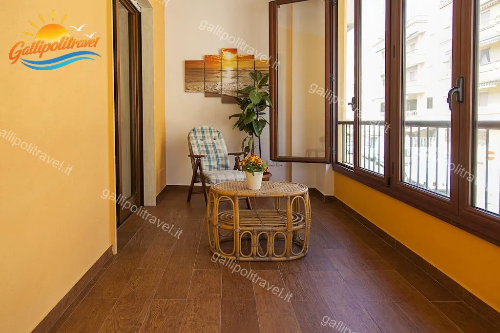 Veranda del Trilocale F1/1 con tavolino rattan e luce naturale