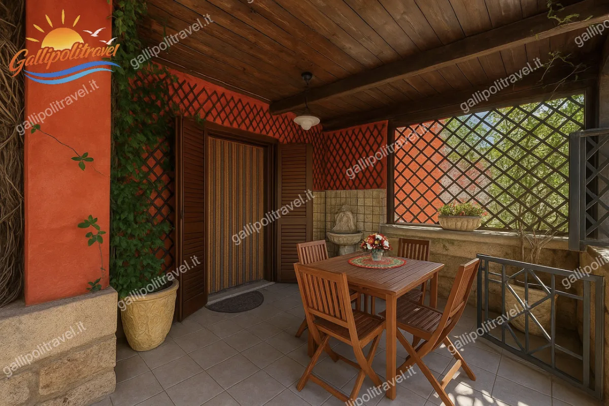 Ampia veranda coperta con pareti dal tocco rustico e tavolo da pranzo in legno per mangiare all'aperto nel Trilocale Green a Baia Verde
