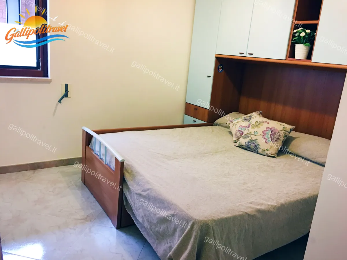Camera del Trilocale H2/2 con letto a ribalta e armadio pensili in legno