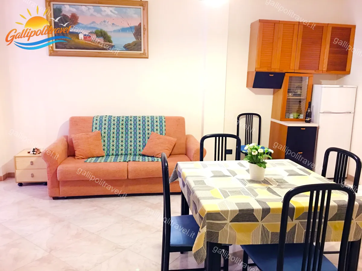 Zona giorno del Trilocale H2/2 con libreria, TV e porta-finestra luminosa