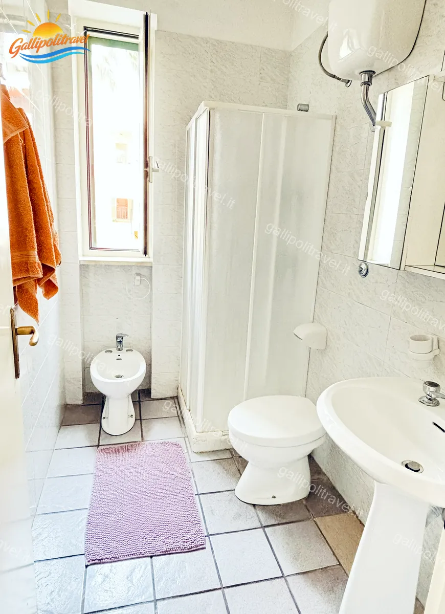 Bagno con doccia a cabina bianca e finestra del Trilocale Mimosa Gallipoli