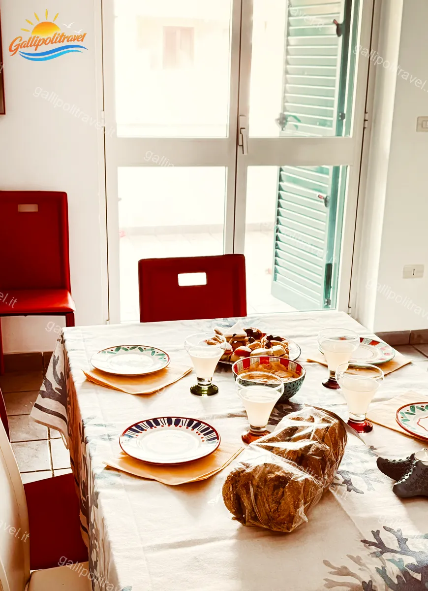 Tavolo da pranzo con luce naturale e porta-finestra del Trilocale Mimosa Gallipoli