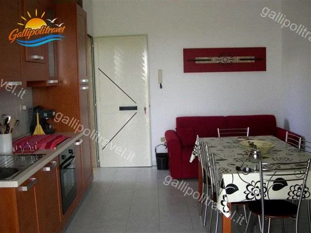 Cucina in legno con tavolo da pranzo e zona giorno del Trilocale Girasole
